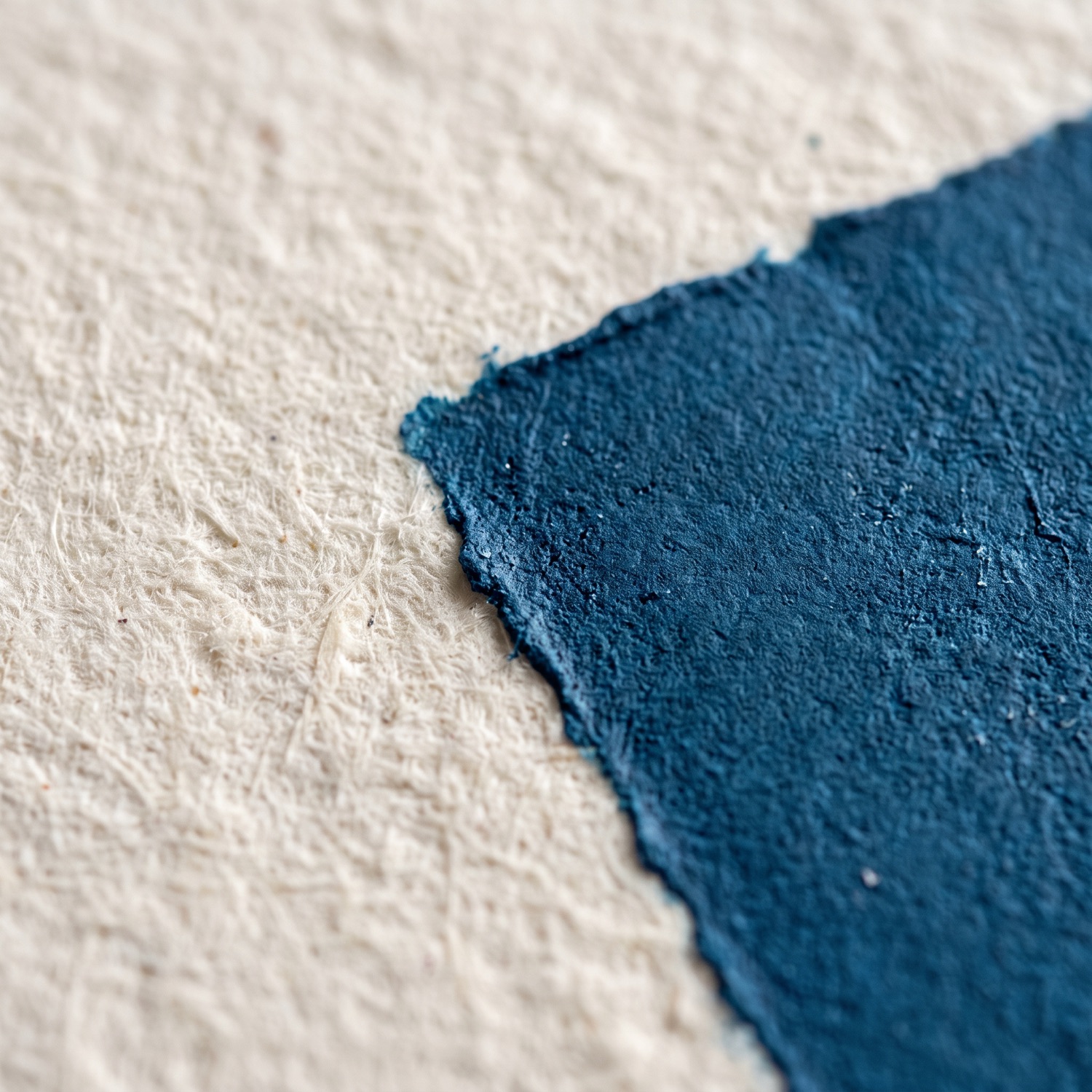Blaue Druckfarbe auf Büttenpapier, Detailaufnahme der Kante