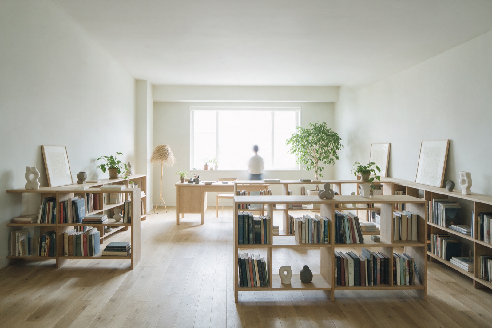 Heller Arbeitsraum mit Bücherregalen und einer Person am Fenster